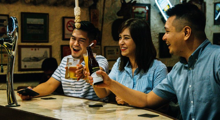 Guests sharing drinks at The Pub at Oasis Hotel